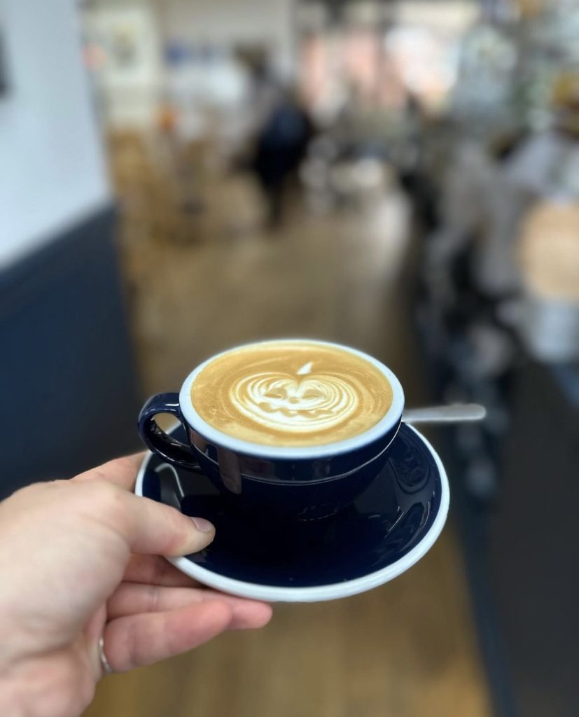 A latte with a pumpkin pattern drawn on top 